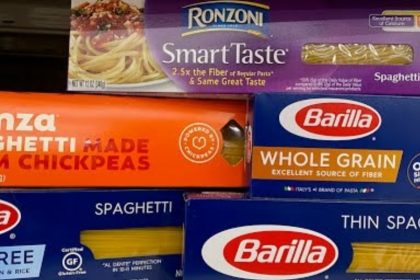 A variety of spaghetti brands and types on a store shelf.