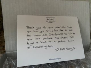 An image with a box of FOMO Bakery gluten-free cookies, with a note from the company included.