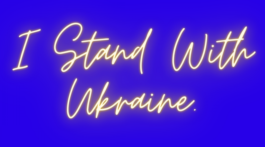 A decorative image with a blue background, and yellow script text that reads "I Stand with Ukraine," in honor of the flag of Ukraine.