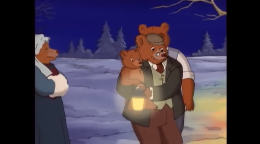 A screenshot from an episode of Little Bear, about their winter solstice celebration. Little Bear is in Grandpa Bear's arms, holding a lantern to hang on the tree for the snow angels. Grandma Bear is on the left hand side. Grandma Bear is wearing an 1890s dress and a bonnet. Grandpa Bear wears a dress shirt, tie, pants, and a vest in the style of the 1890s.