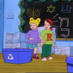 Screenshot from a holiday episode of The Magic School Bus, w/ Dorothy Ann and Ralph standing in front of a chalkboard decorated w/ menorahs and the Star of David. Dorothy Ann and Ralph are standing next to blue recycling bins.