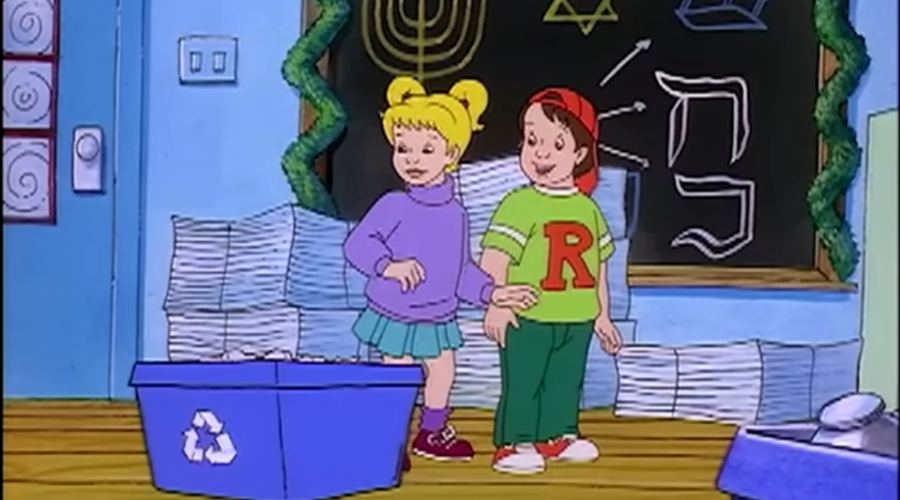 Screenshot from a holiday episode of The Magic School Bus, w/ Dorothy Ann and Ralph standing in front of a chalkboard decorated w/ menorahs and the Star of David. Dorothy Ann and Ralph are standing next to blue recycling bins.