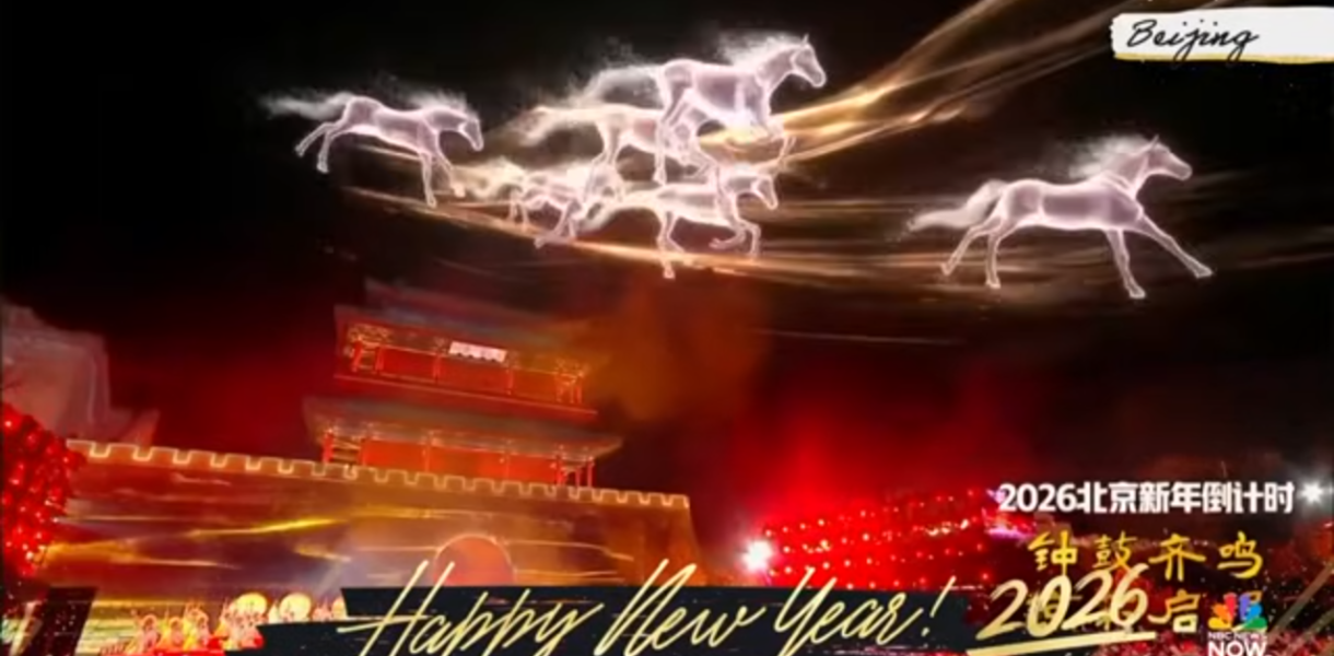 Screenshot from NBC News Now Fireworks Around the World, with footage from New Years Eve 2026 in Beijing, China. A light show in reds and yellows fills the screen, with white holographic horses galloping across the screen. Happy New Year 2026!
