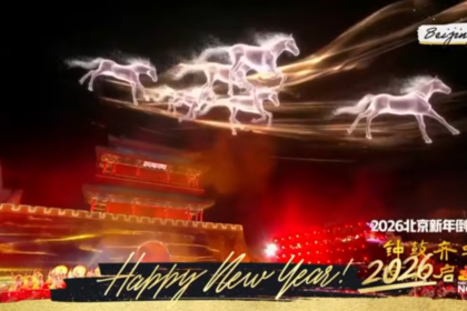 Screenshot from NBC News Now Fireworks Around the World, with footage from New Years Eve 2026 in Beijing, China. A light show in reds and yellows fills the screen, with white holographic horses galloping across the screen. Happy New Year 2026!